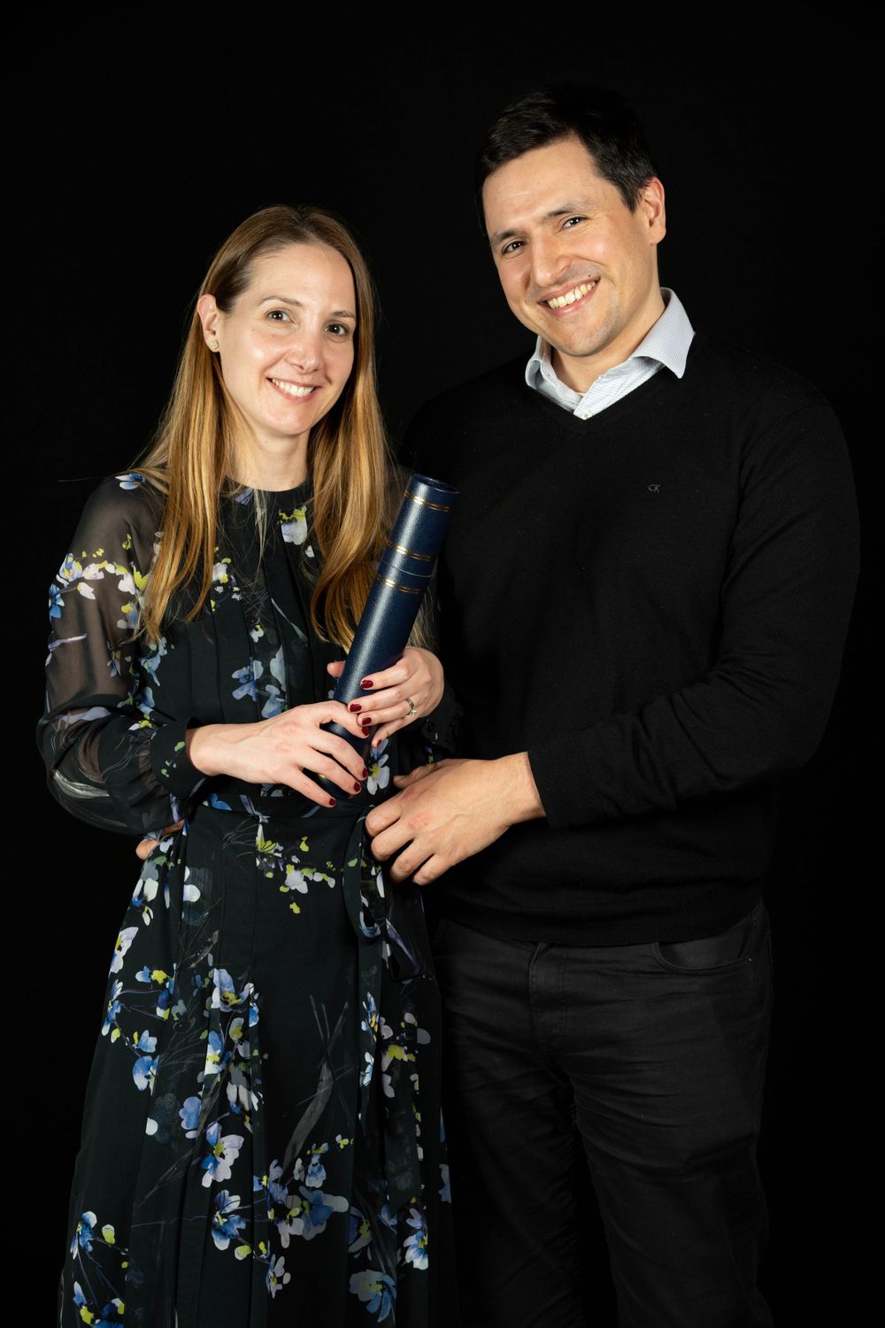 charterholder portrait of a couple against a black background