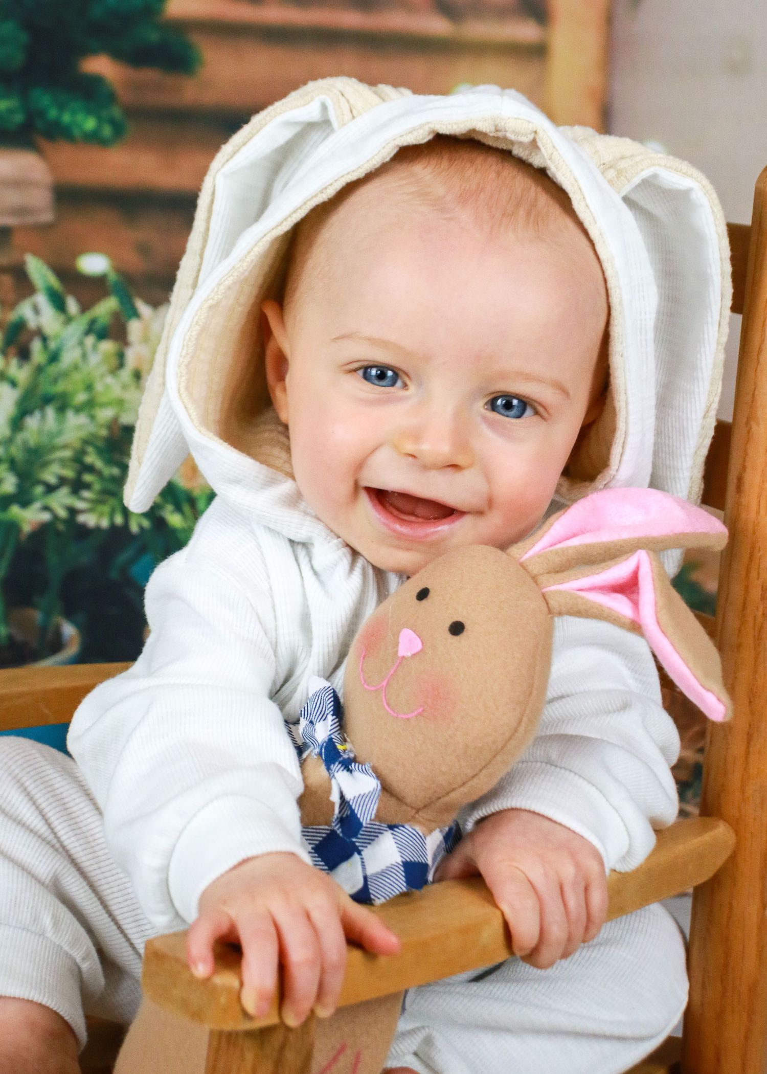 Spring themed portrait setup with bunny plush toy and greenery backdrop.