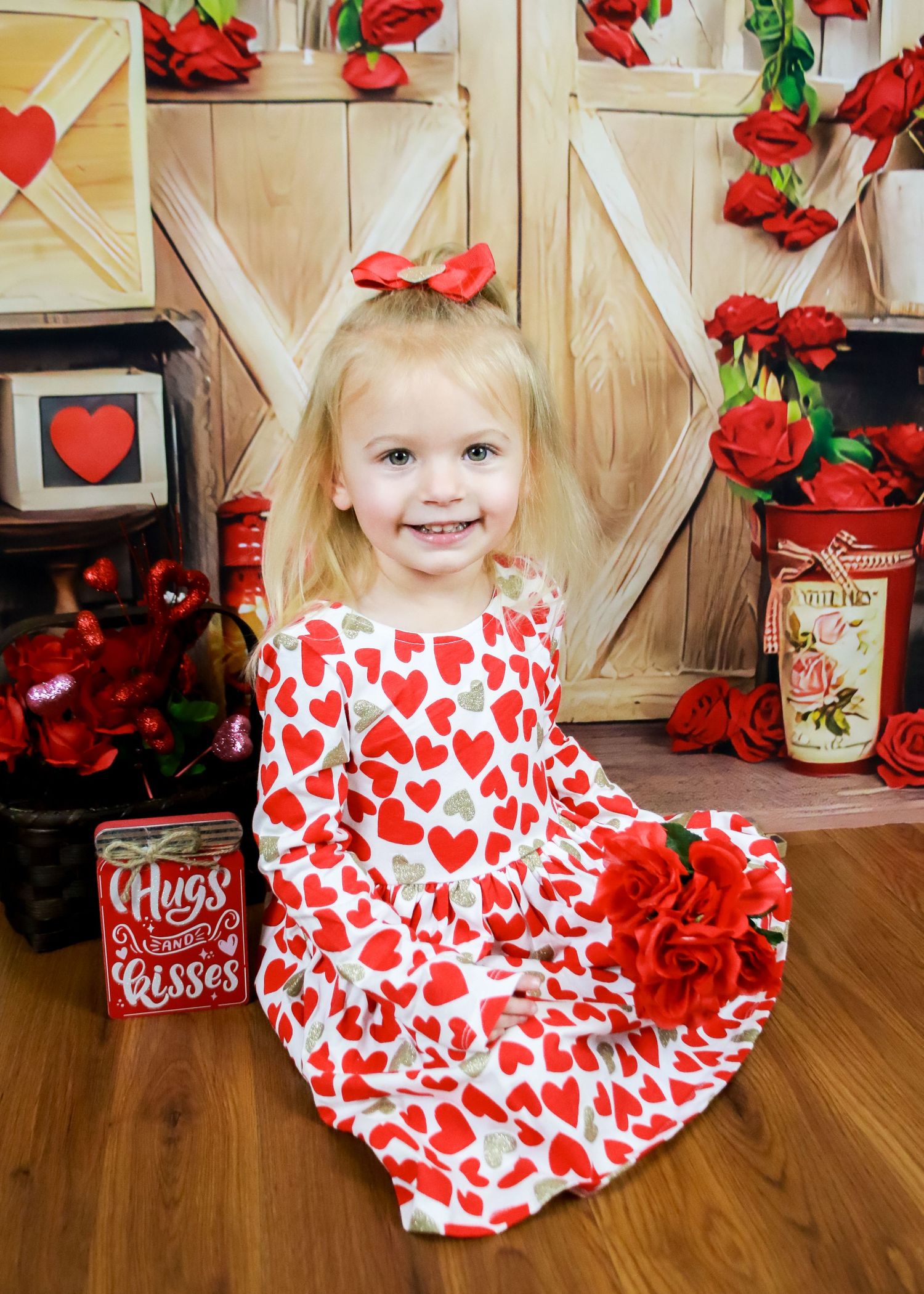 Valentine's Day setup with red roses, heart patterns, and romantic decorations against wooden backdrop.