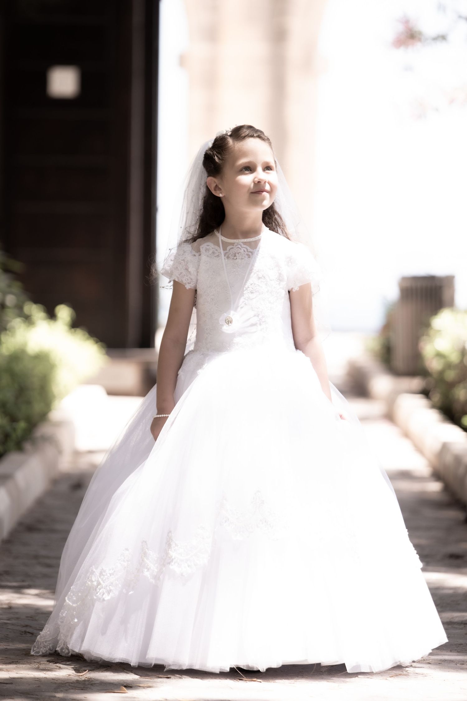 Multiple views of an ornate white dress with a full tulle skirt photographed in natural lighting.