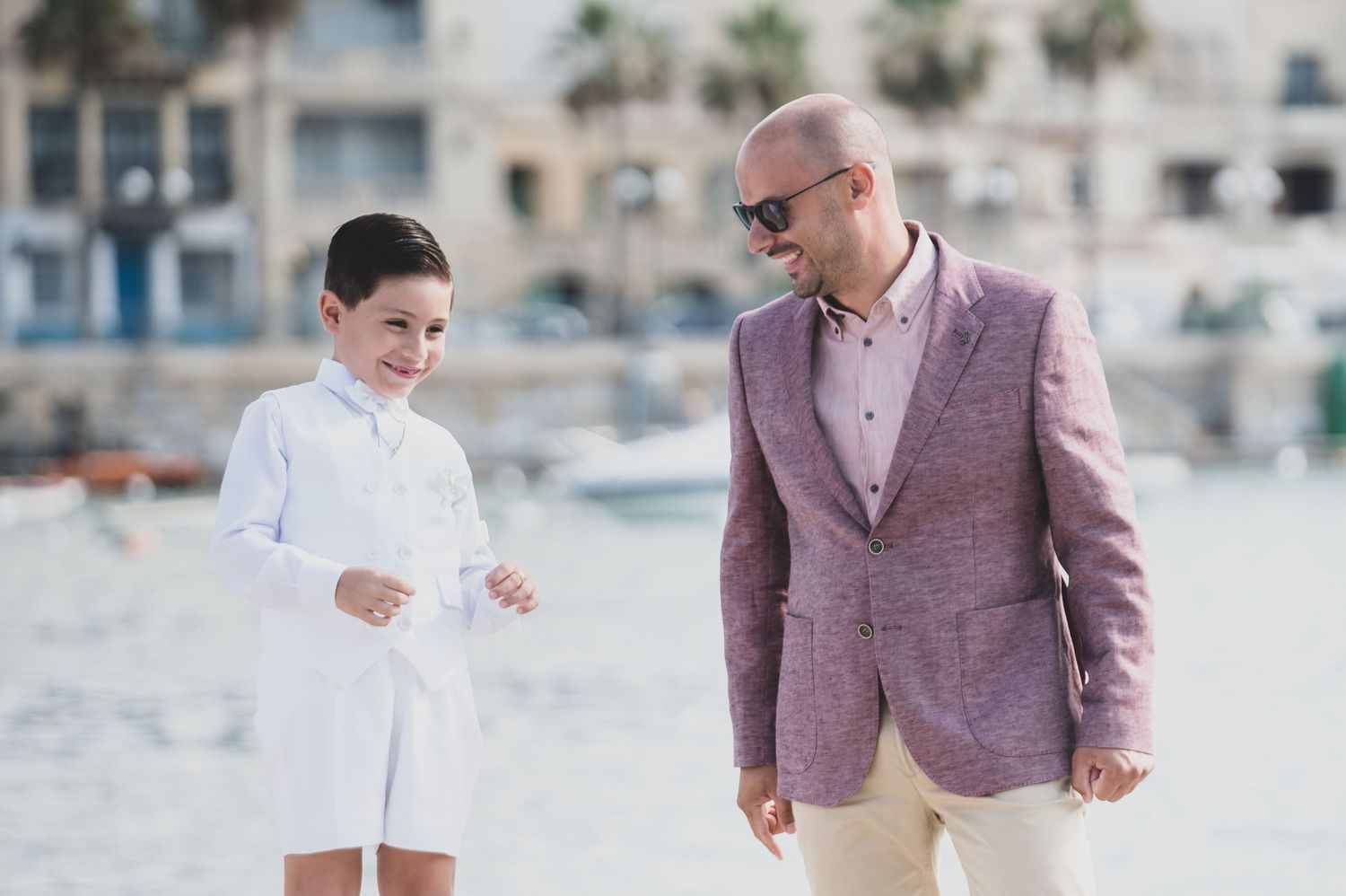 Two people walking and talking together on a sunny beach.