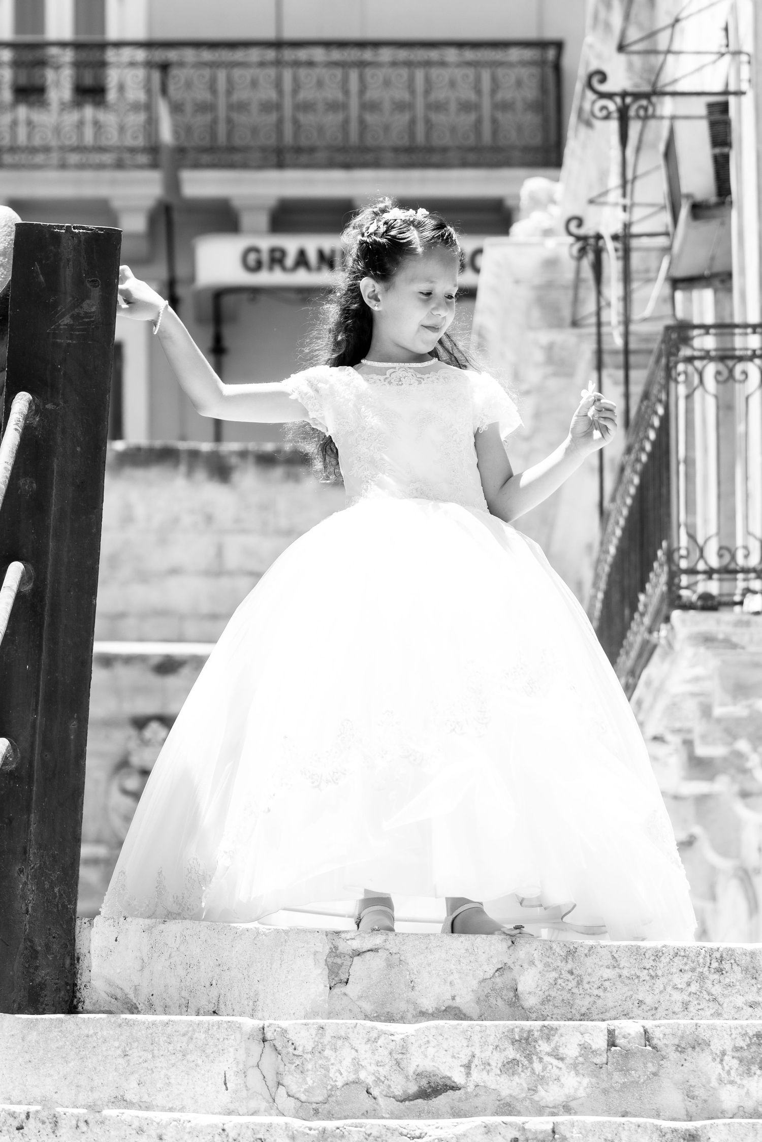 A white ballgown dress photographed in a series of artistic black and white frames against stone steps.
