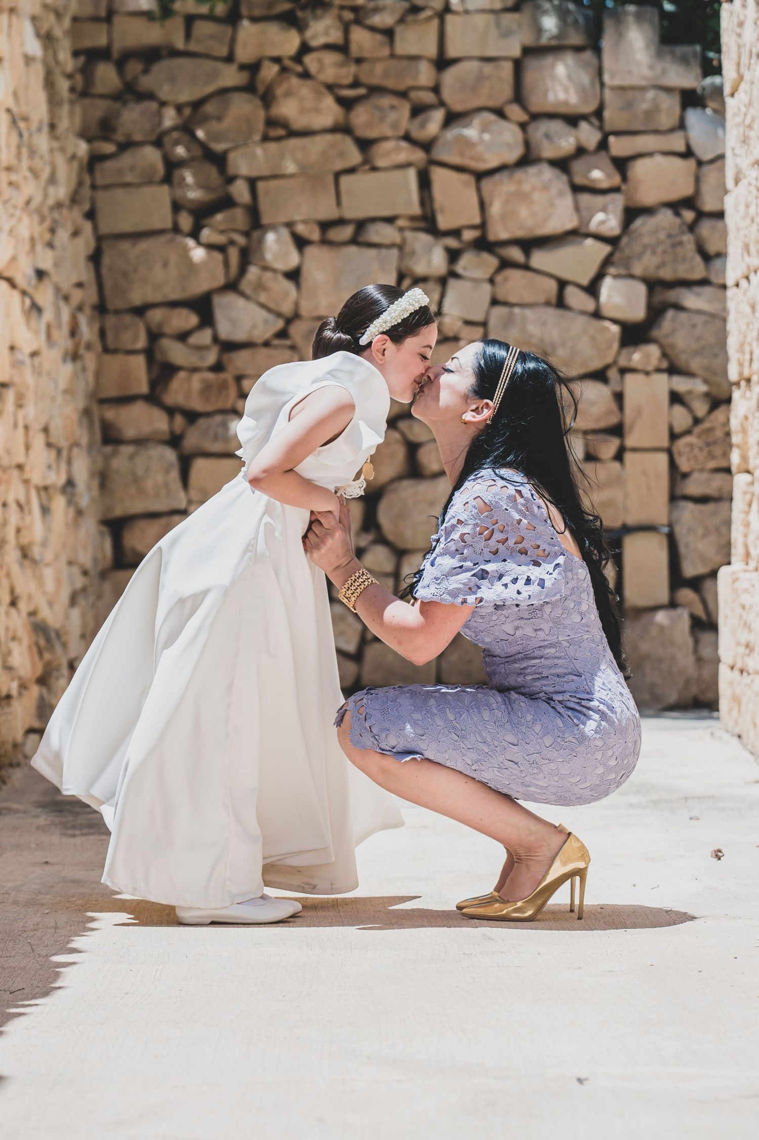 A photographer in purple dress takes creative photos in a stone-walled venue.