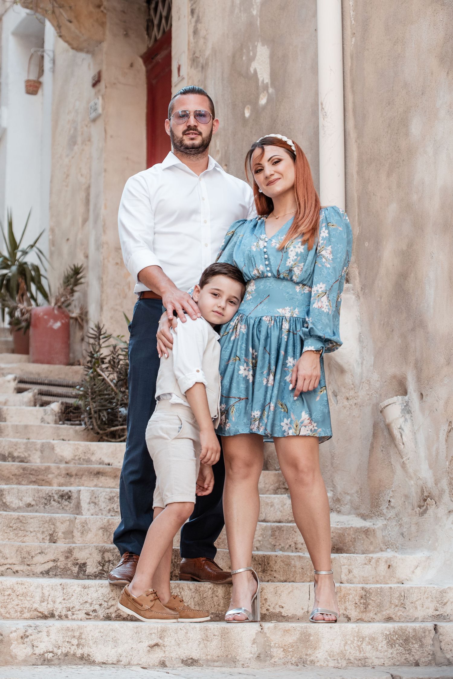 Family photoshoot on rustic stone steps with blue and cream colored outfits.