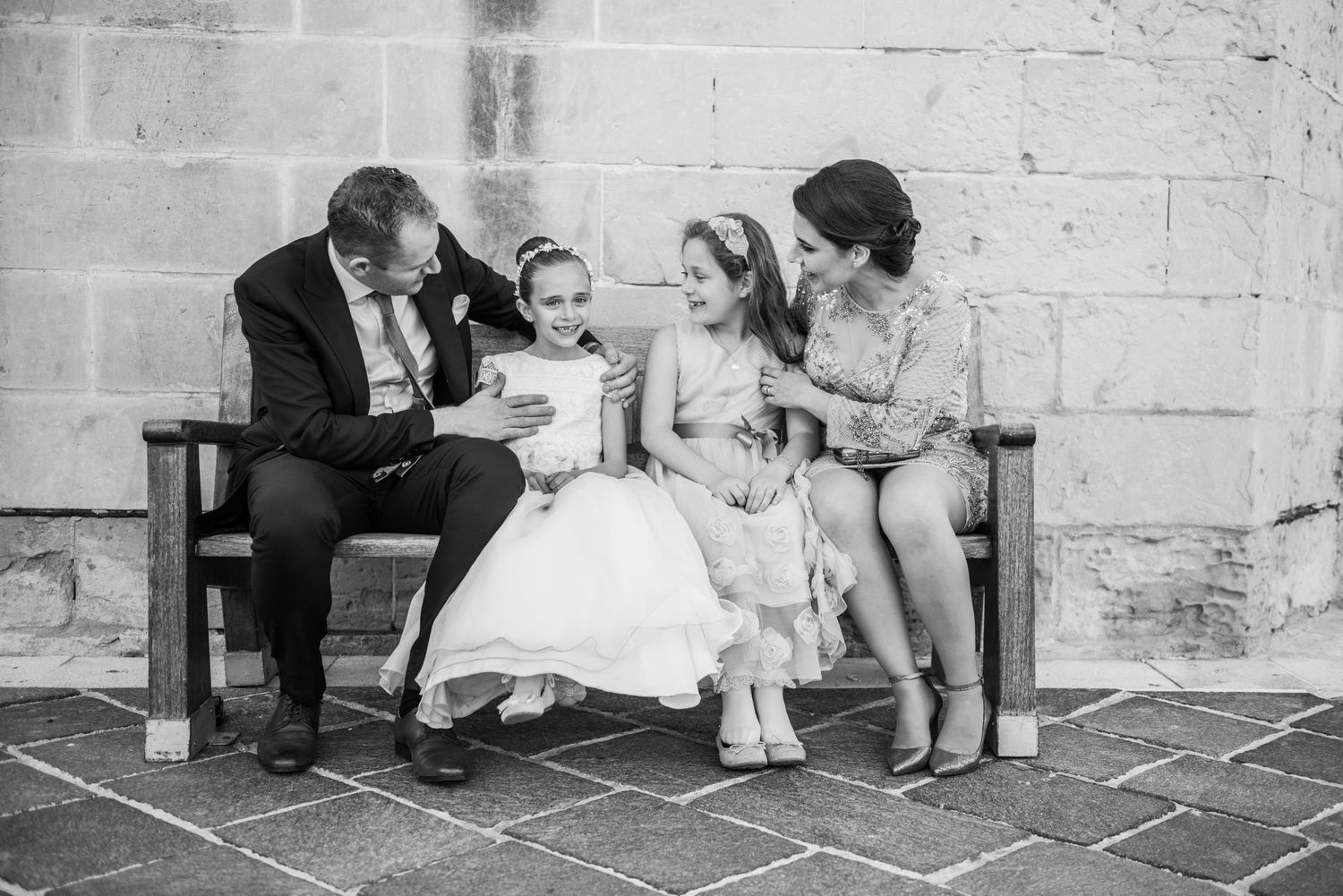 Group sitting on stone steps playing hopscotch during a formal gathering.