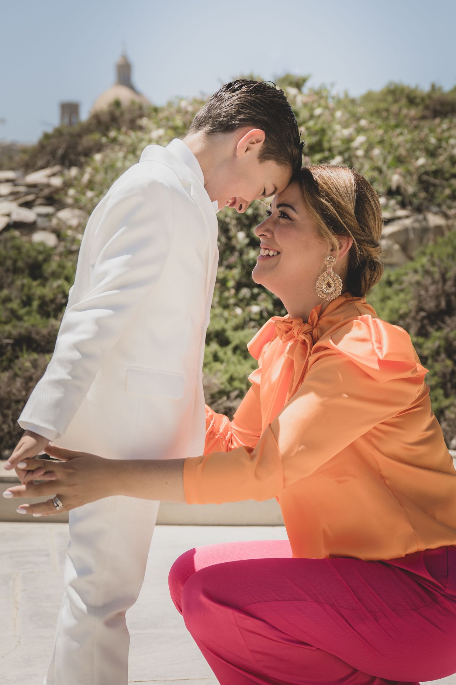 A tender moment shared between two people in a sunny outdoor setting.