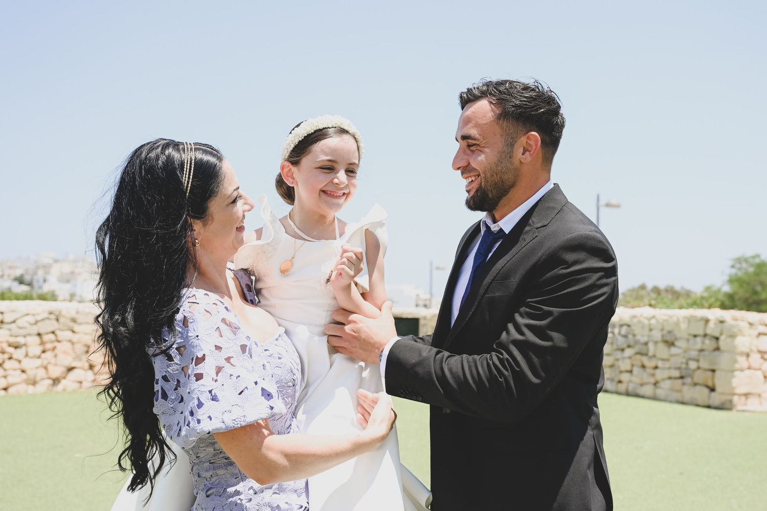 A celebratory dance sequence captured outdoors with stone walls in the background.