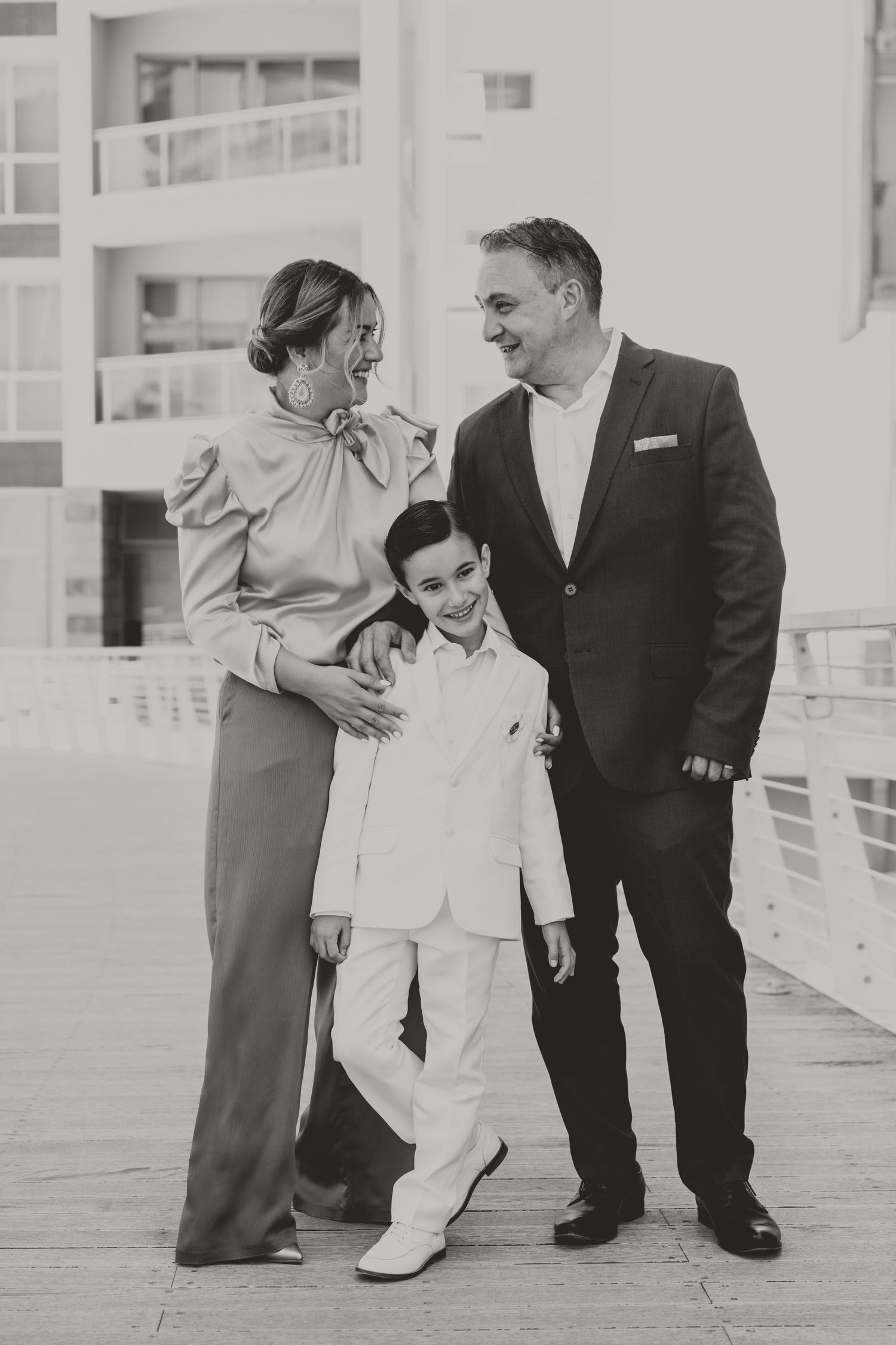 A family shares a joyful moment together on a bright outdoor deck.