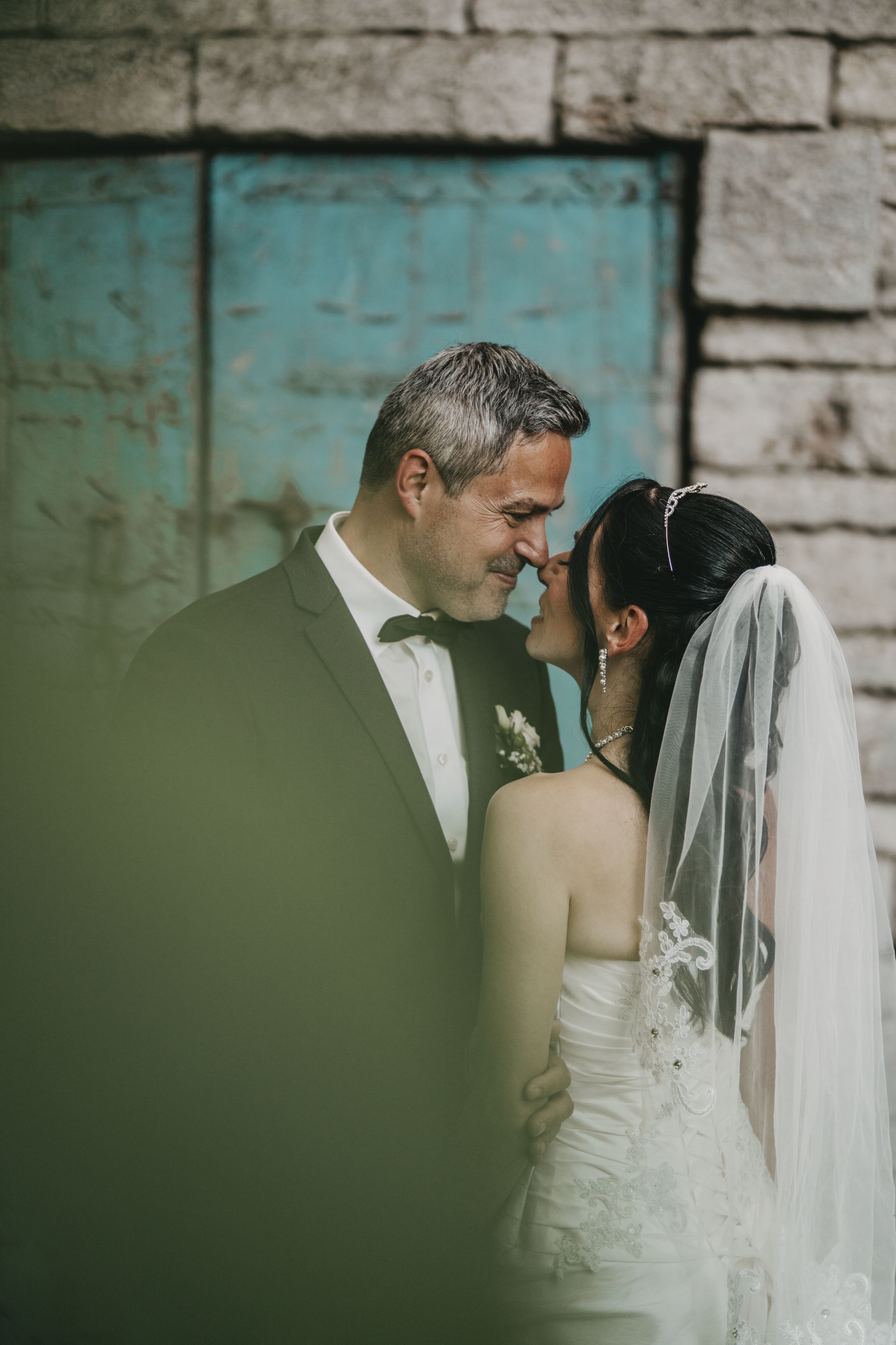 Close-up sequence of a romantic wedding couple sharing an intimate moment against a stone wall.
