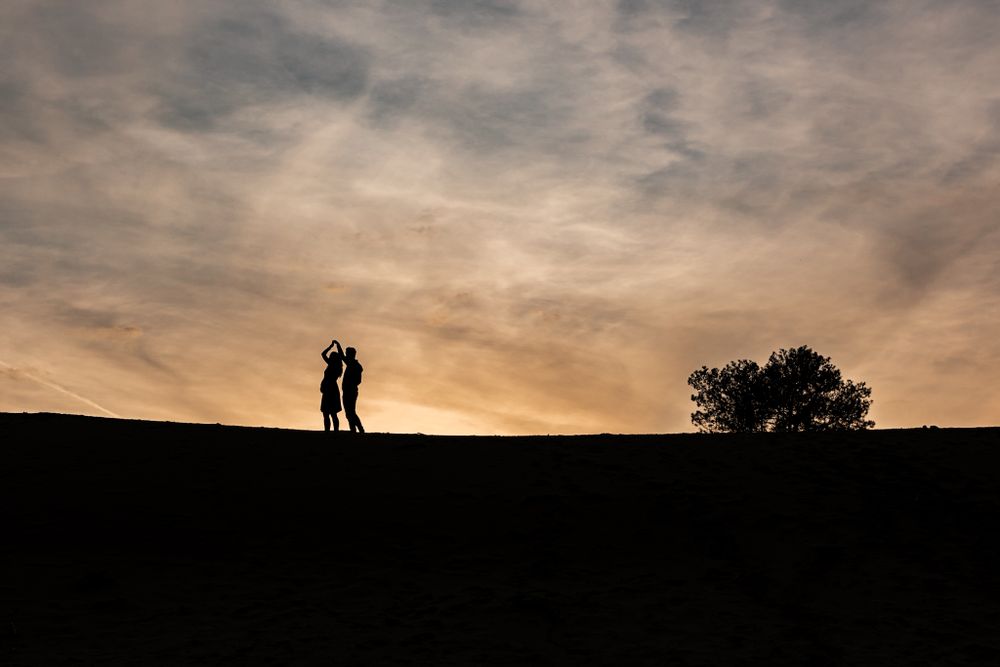 Unieke foto bij zonsondergang met het silhouette van een zwanger koppel in Limburg