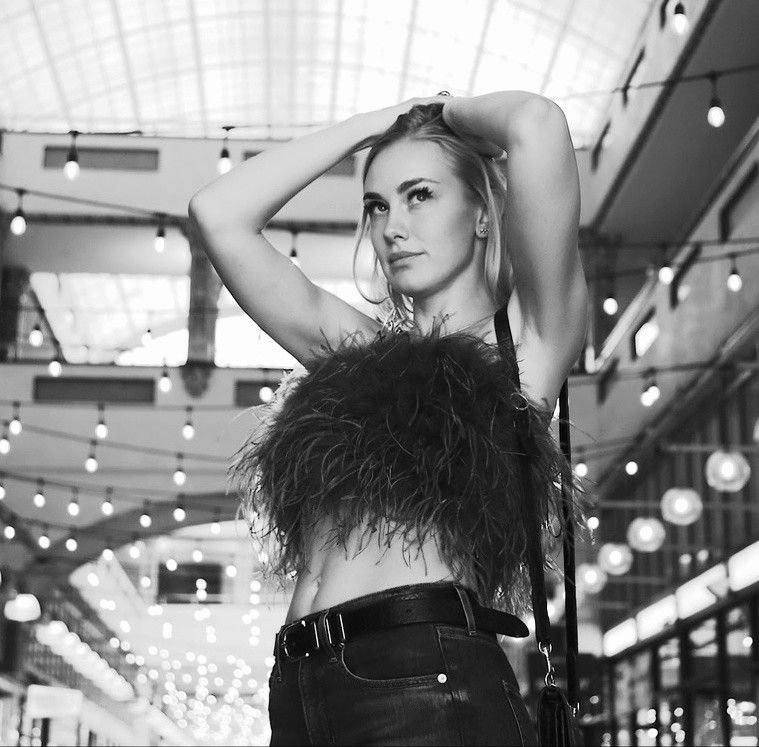 Black and white artistic fashion photo showing blonde female model posing elegantly in downtown Los Angeles architectural setting.