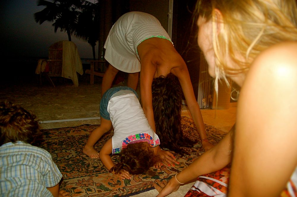 People playfully posing on the floor at a casual indoor gathering.