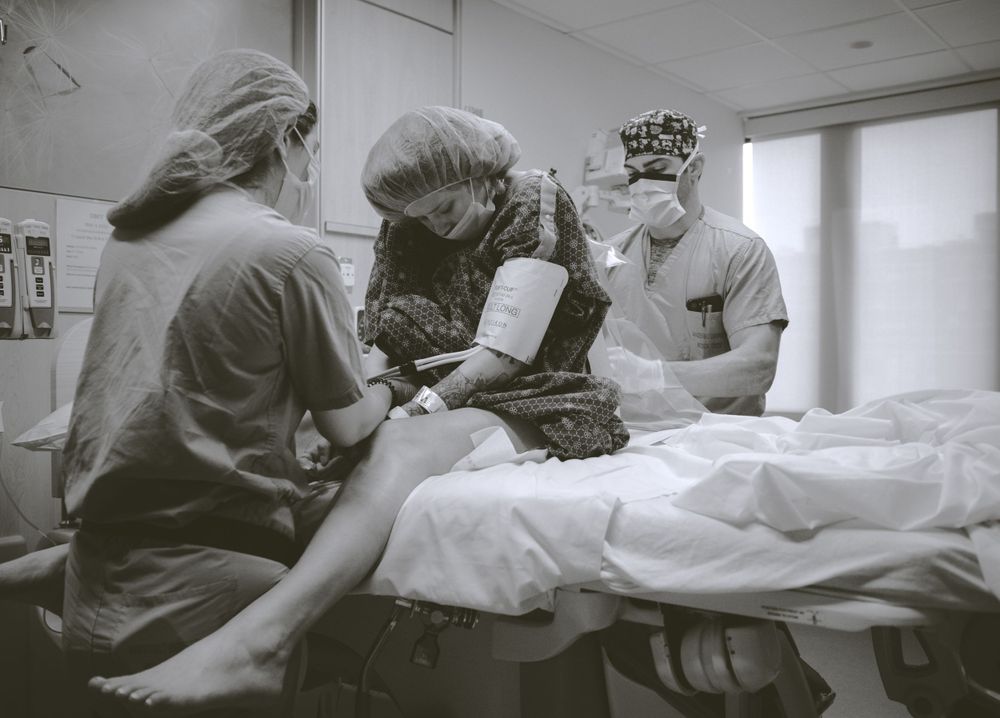 Healthcare providers working together in a hospital room with medical equipment.