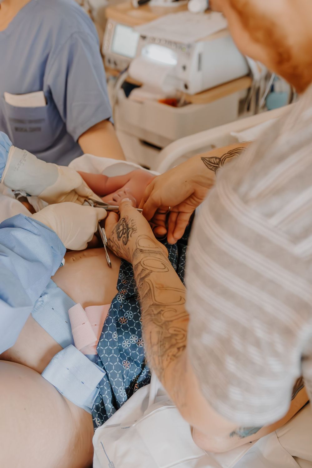Medical professionals in protective gear attending to a patient during a procedure.