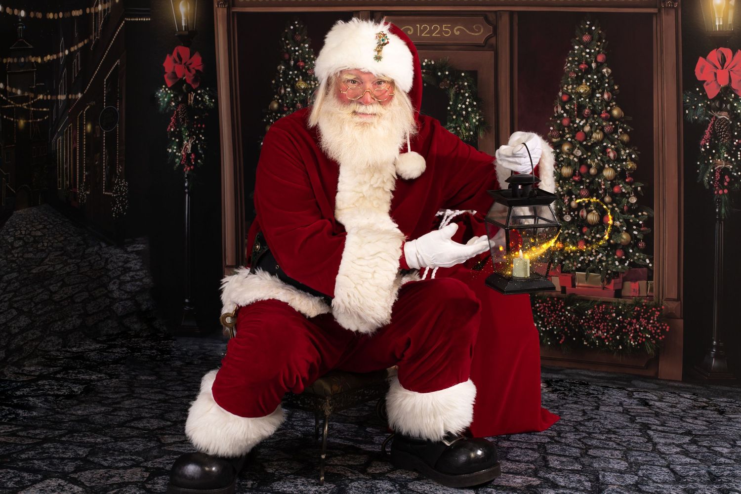 Traditional Santa Claus seated in festive holiday setting with decorated Christmas trees.