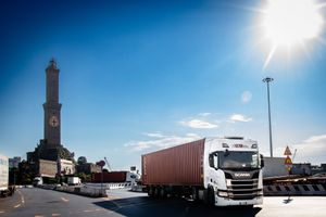 camion per spedizioni intermodali nel porto di genova con la lanterna sullo sfondo