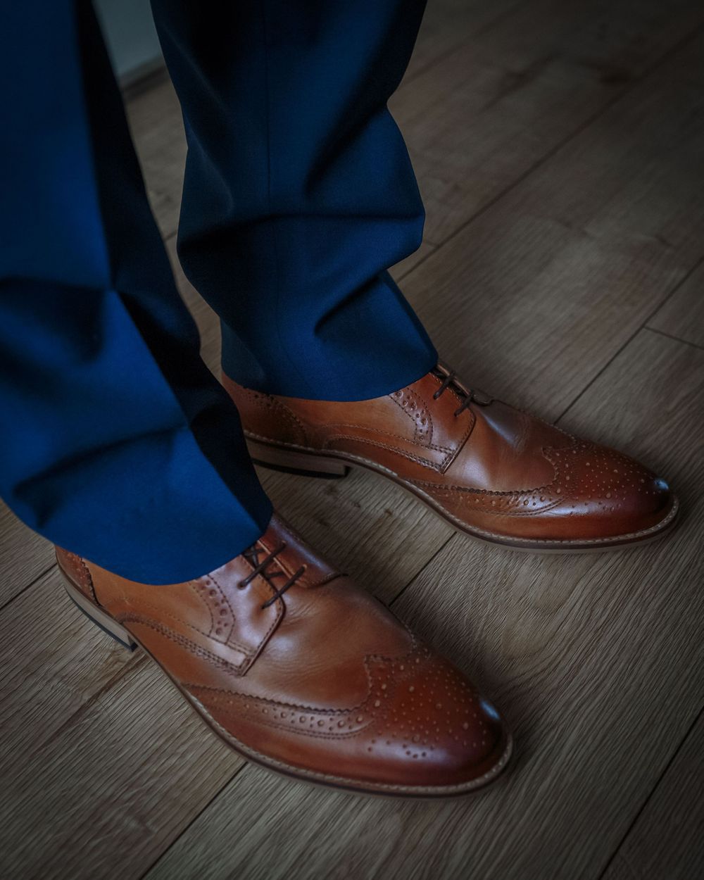 shot of grooms brown shoes and blue trousers