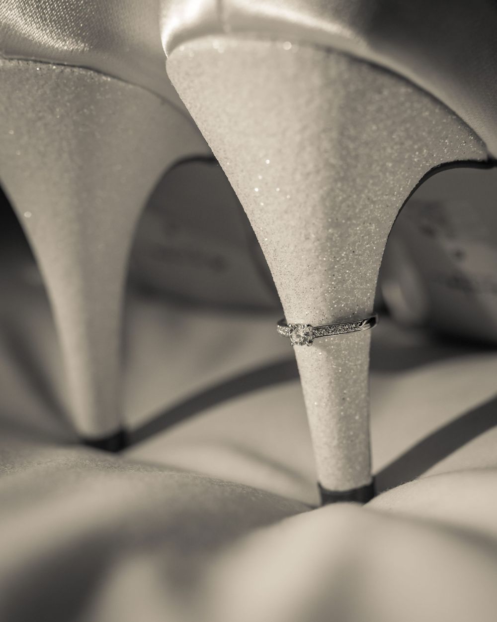 brides engagement ring on the heel of her wedding shoes