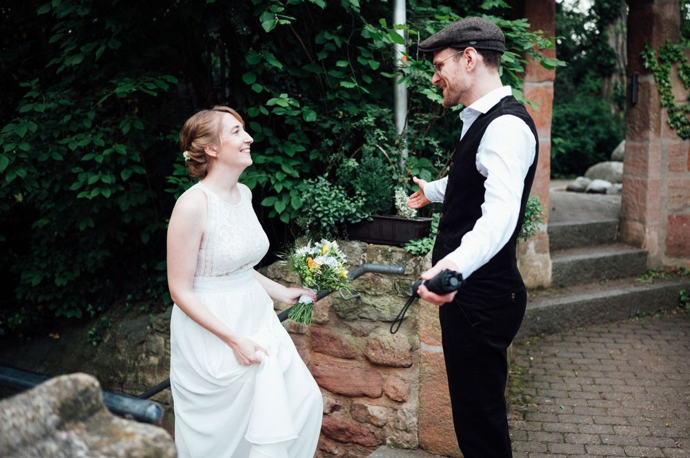 A couple sharing a joyful moment during their wedding in a garden setting.