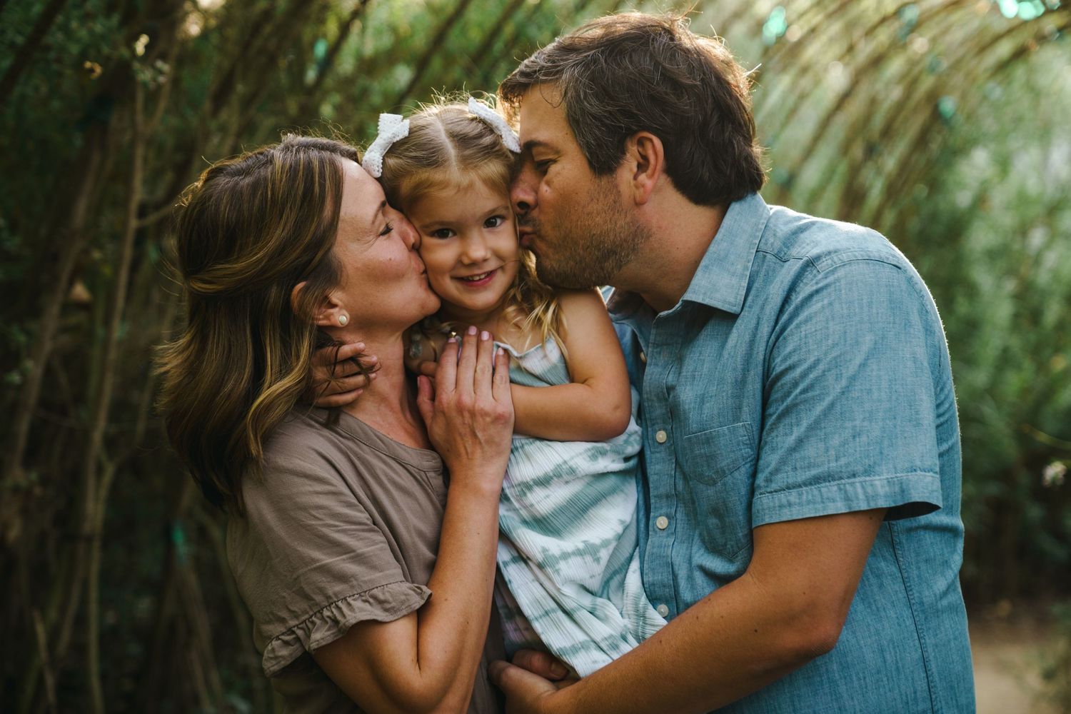 Intimate family moment captured in lush garden setting.