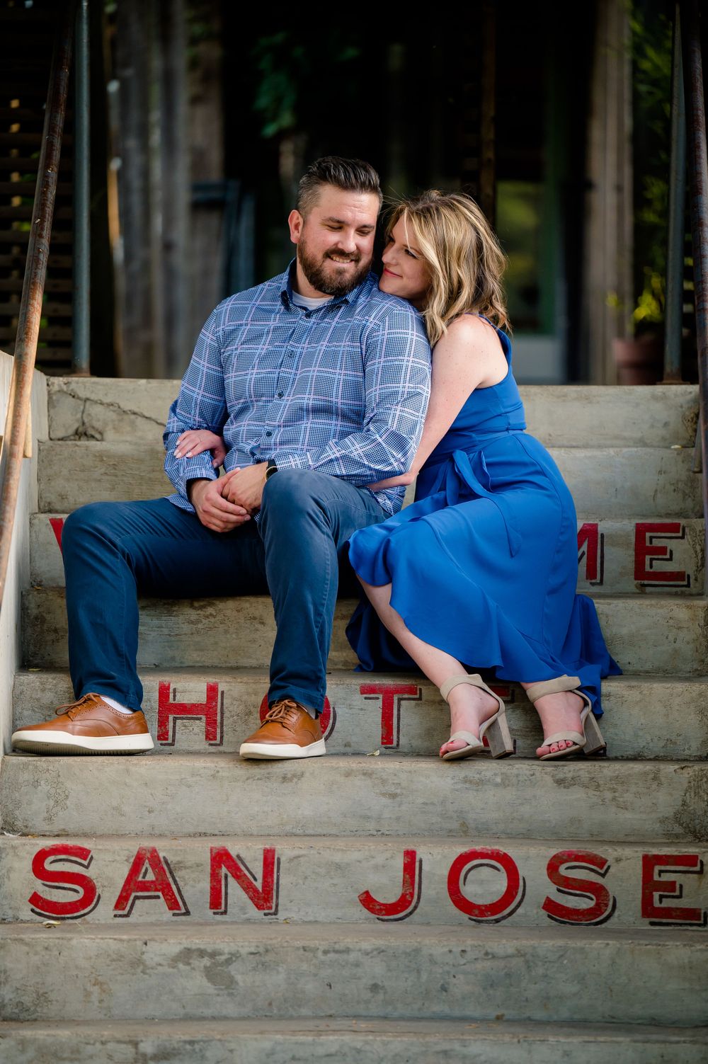Couple sitting close together on San Jose steps sharing tender moment.Congress Avenue Engagement session Austin