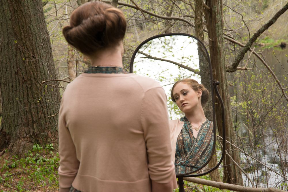 A reflective moment captured with an antique mirror in a wooded setting.