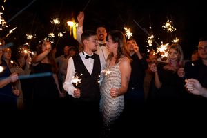 Wedding celebration at night with sparklers creating magical atmosphere.