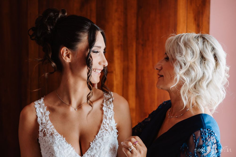 Tender moment shared during wedding preparations in warm natural lighting.