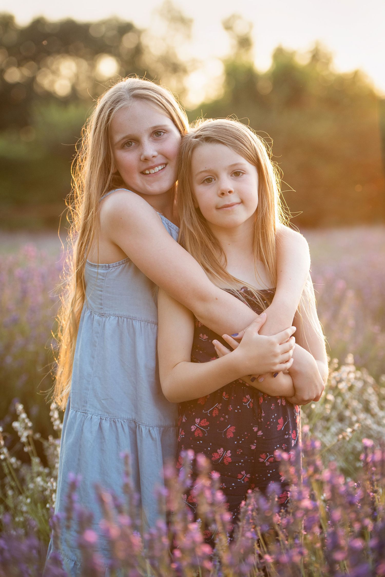 Two young people embrace in a blooming lavender field at sunset.