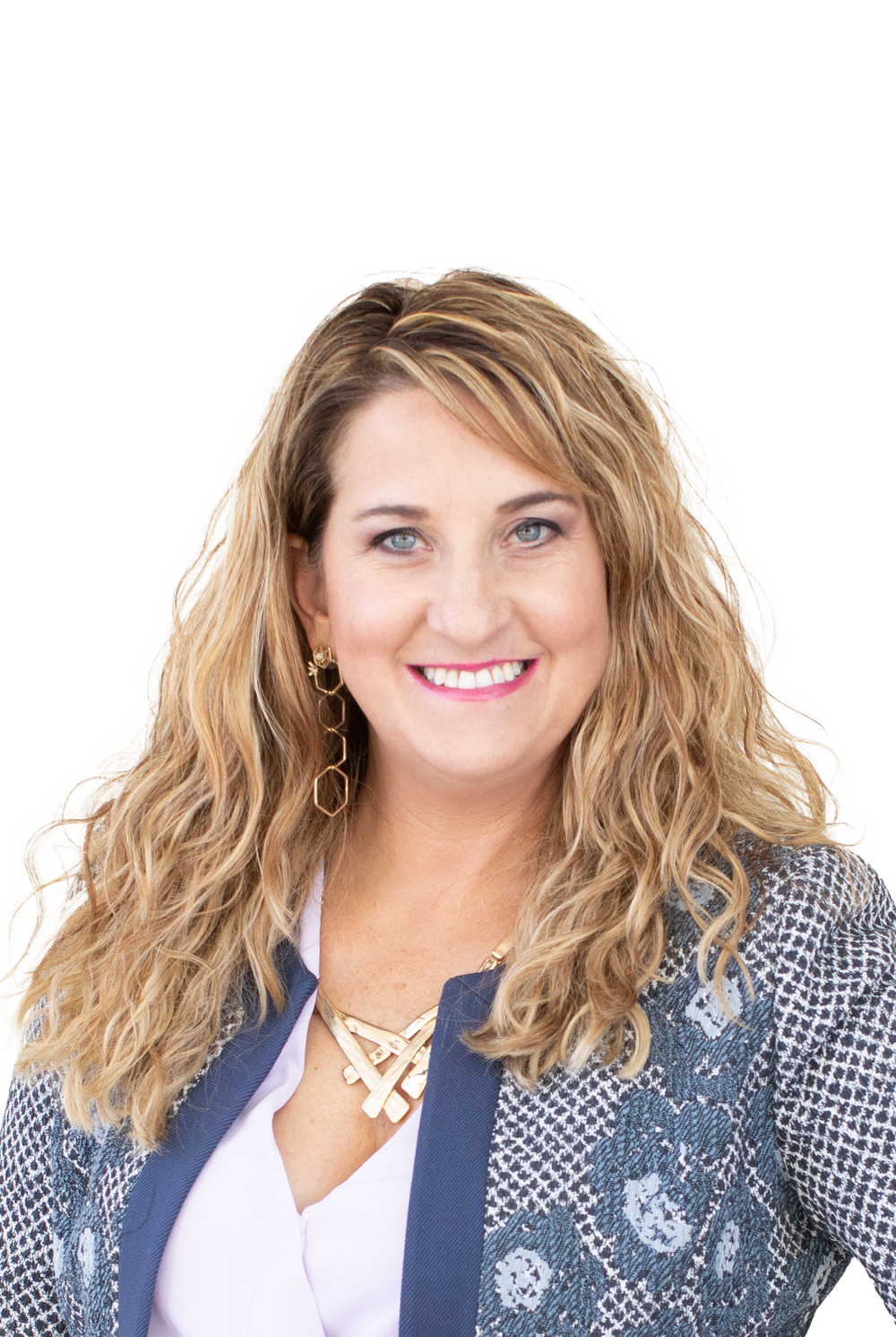 Professional portrait of woman in business attire with wavy blonde hair against white background.