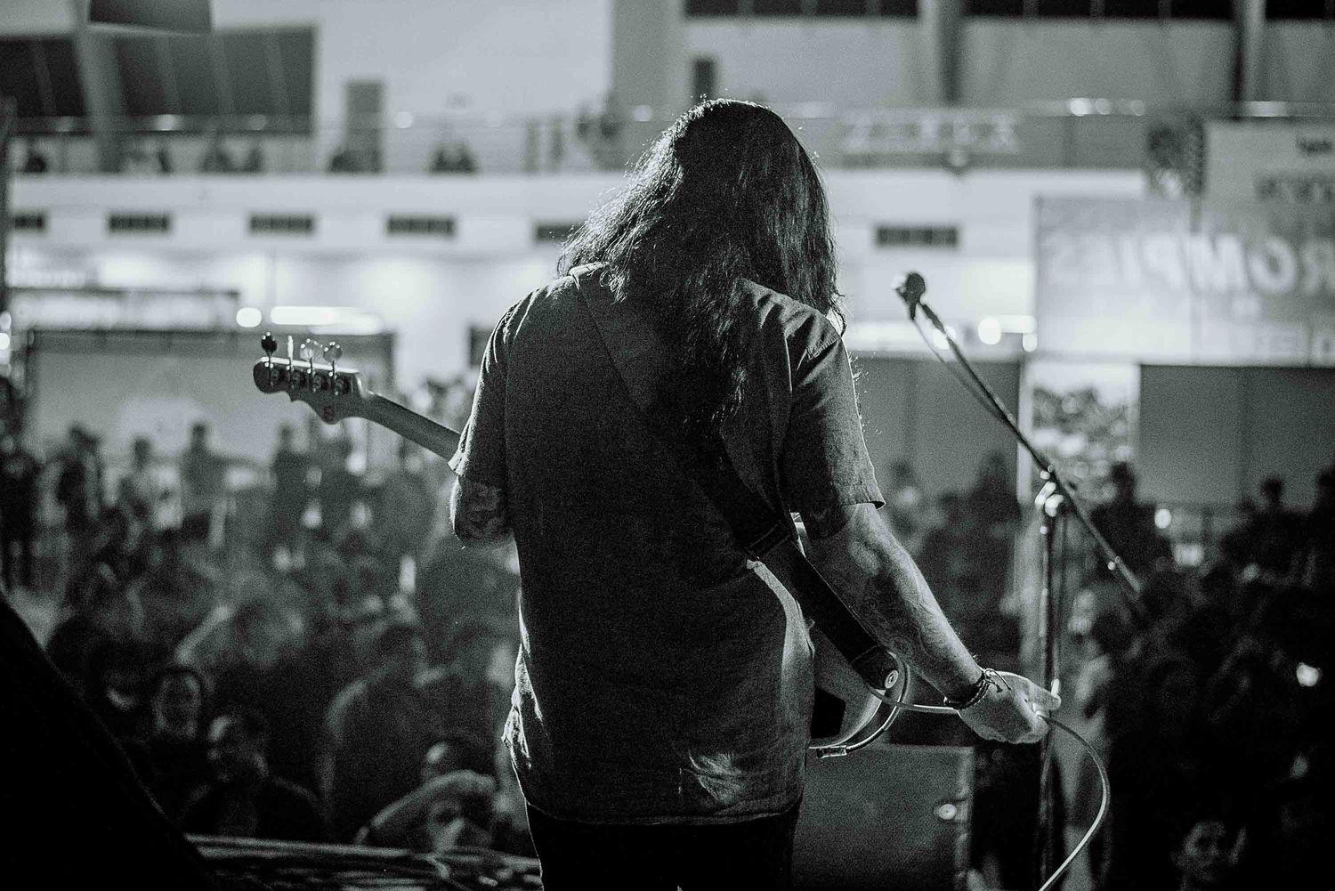 Silhouette of musician performing on stage in black and white.