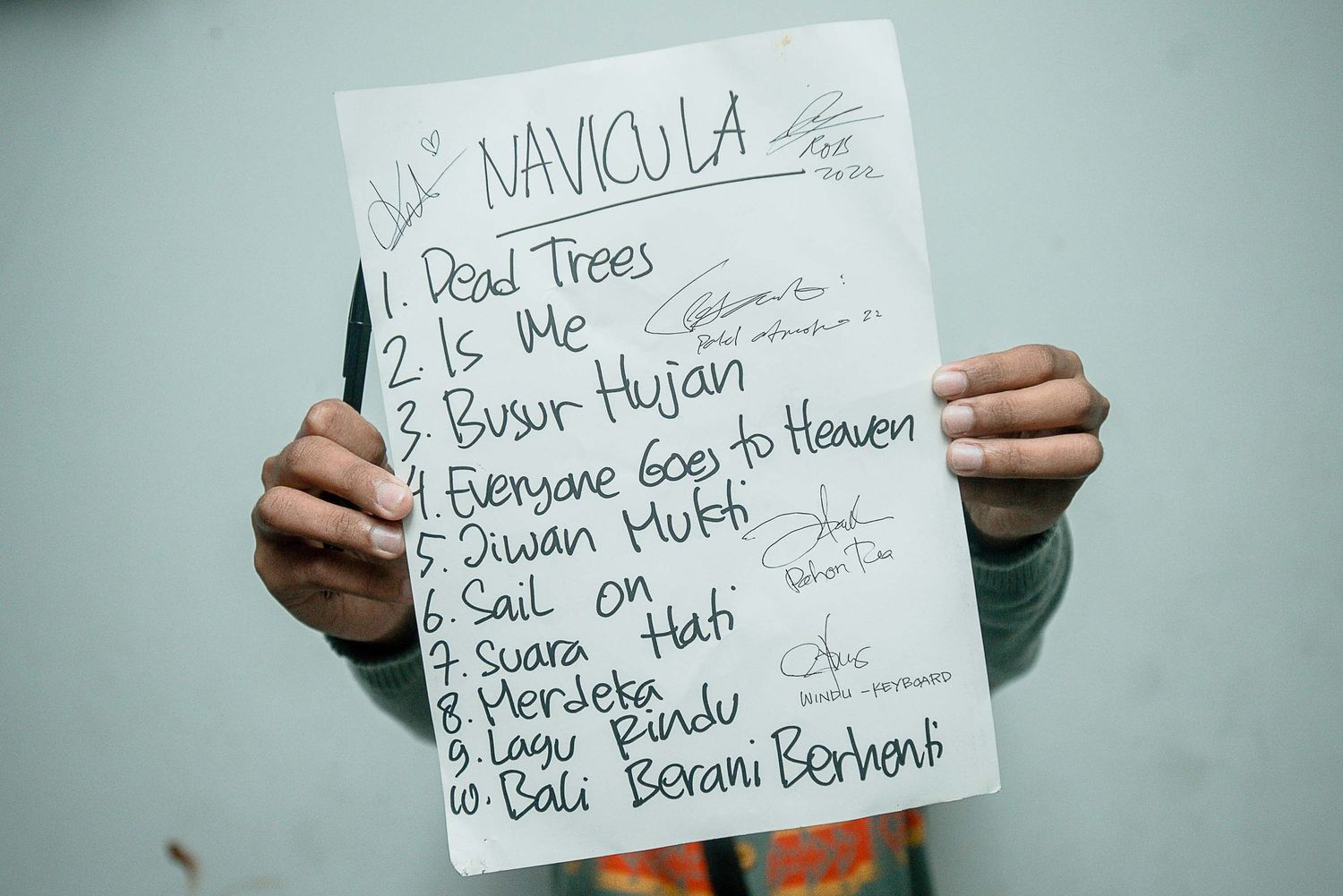 Handwritten setlist on white paper showing song titles and performance order.