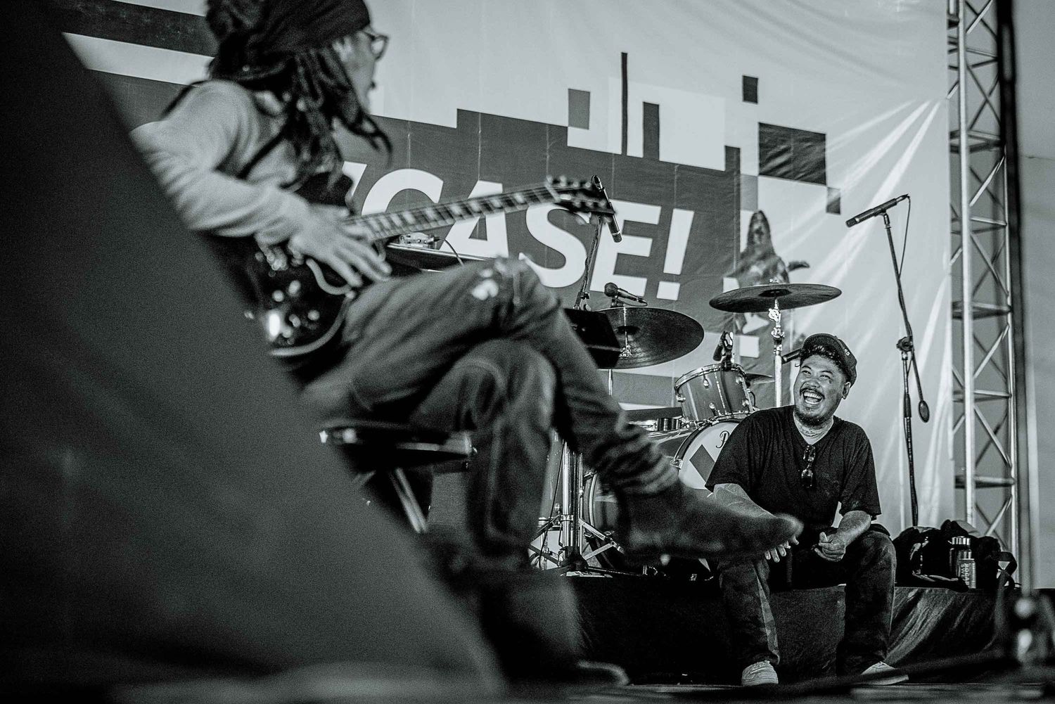 Black and white photo of band members performing energetically on stage.