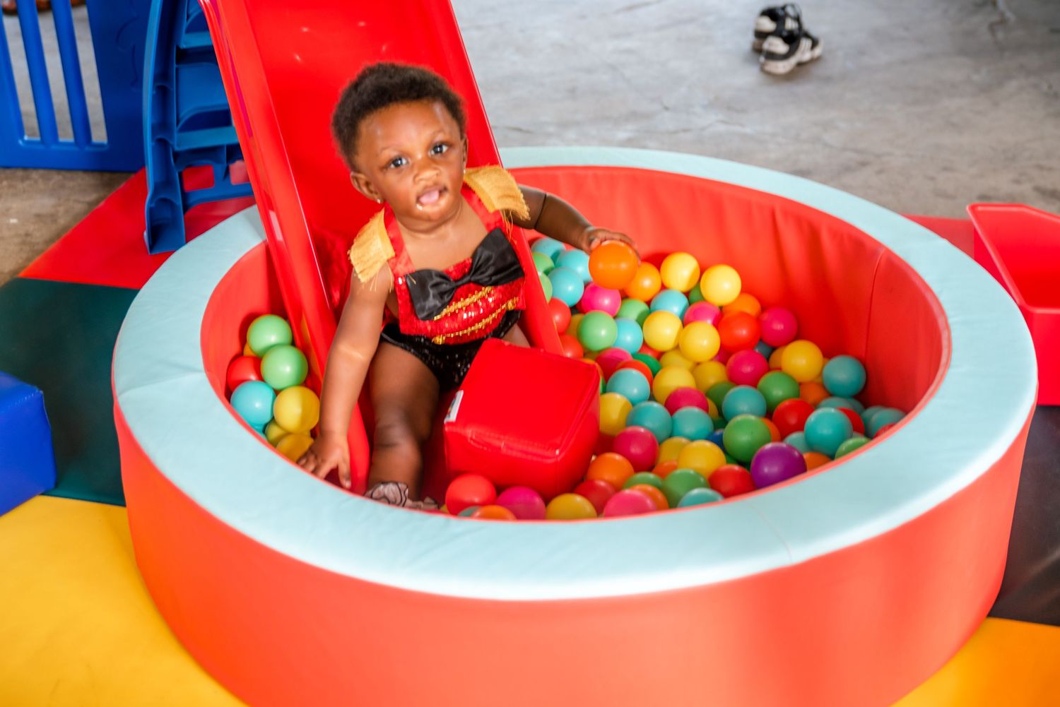Colorful ball pit play area featuring red inflatable pool filled with bright plastic balls.