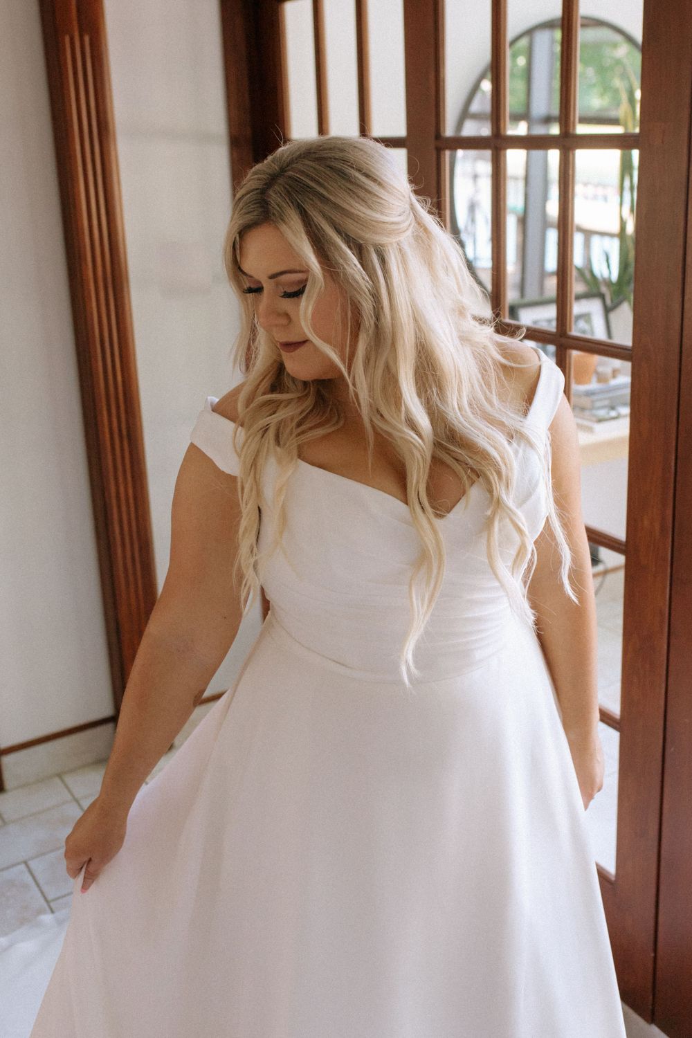 Close-up view of bride in fitted bodice wedding dress with cap sleeves.