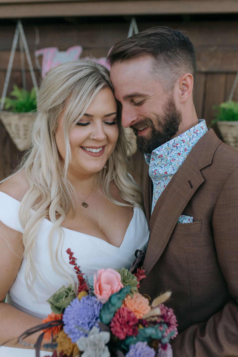 An intimate moment between newlyweds as they share a close embrace with a beautiful bouquet.
