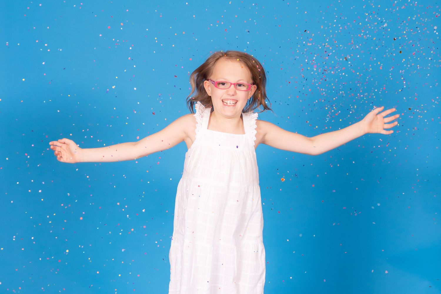 kid jumping and throwing confetti on savage blue jay backdrop with confetti in studio in clayton new jersey gloucester