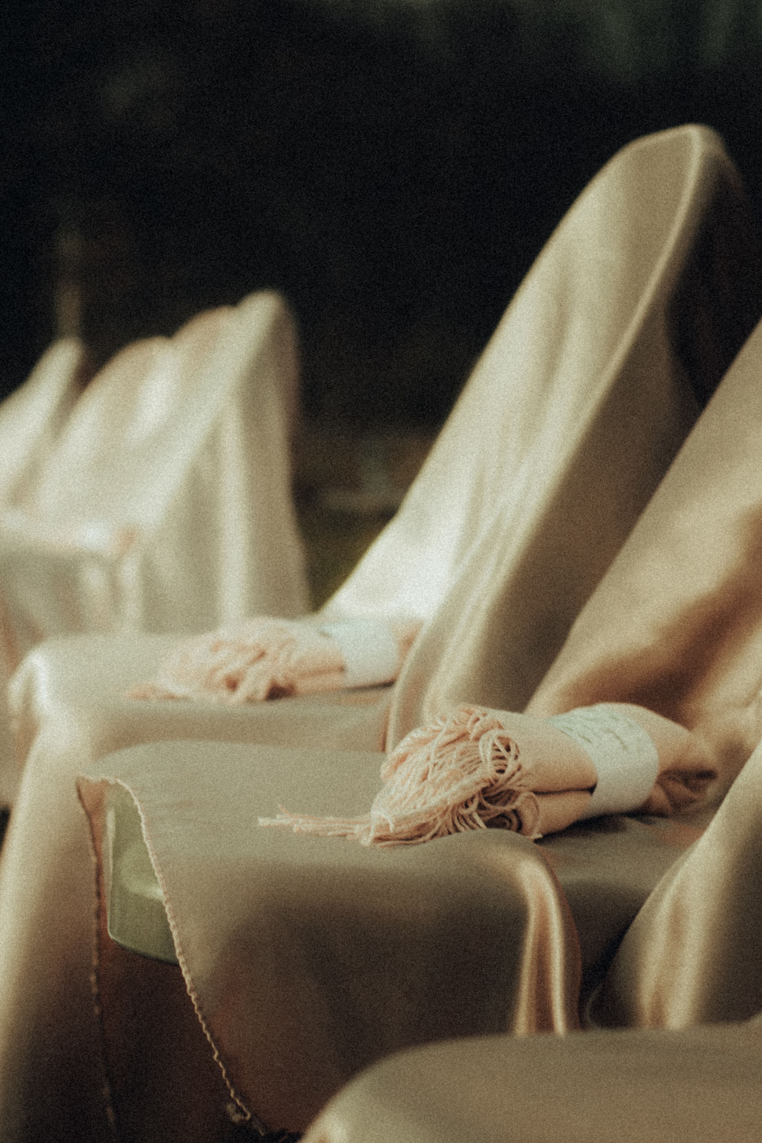 Delicate ballet pointe shoes rest on cream-colored theater seating.