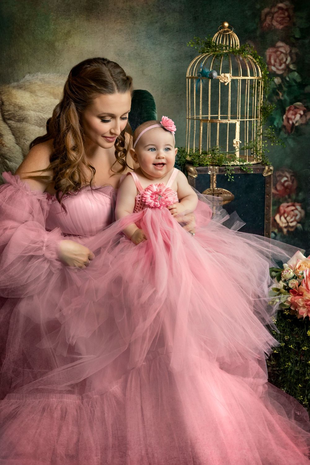 Romantic portrait with vintage birdcage and roses featuring matching pink tulle dresses.