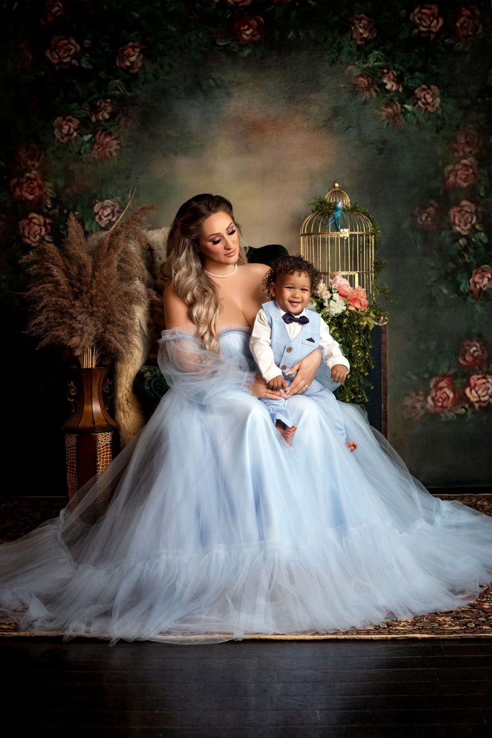 Elegant portrait with decorative birdcage and roses in ethereal blue tulle gowns.