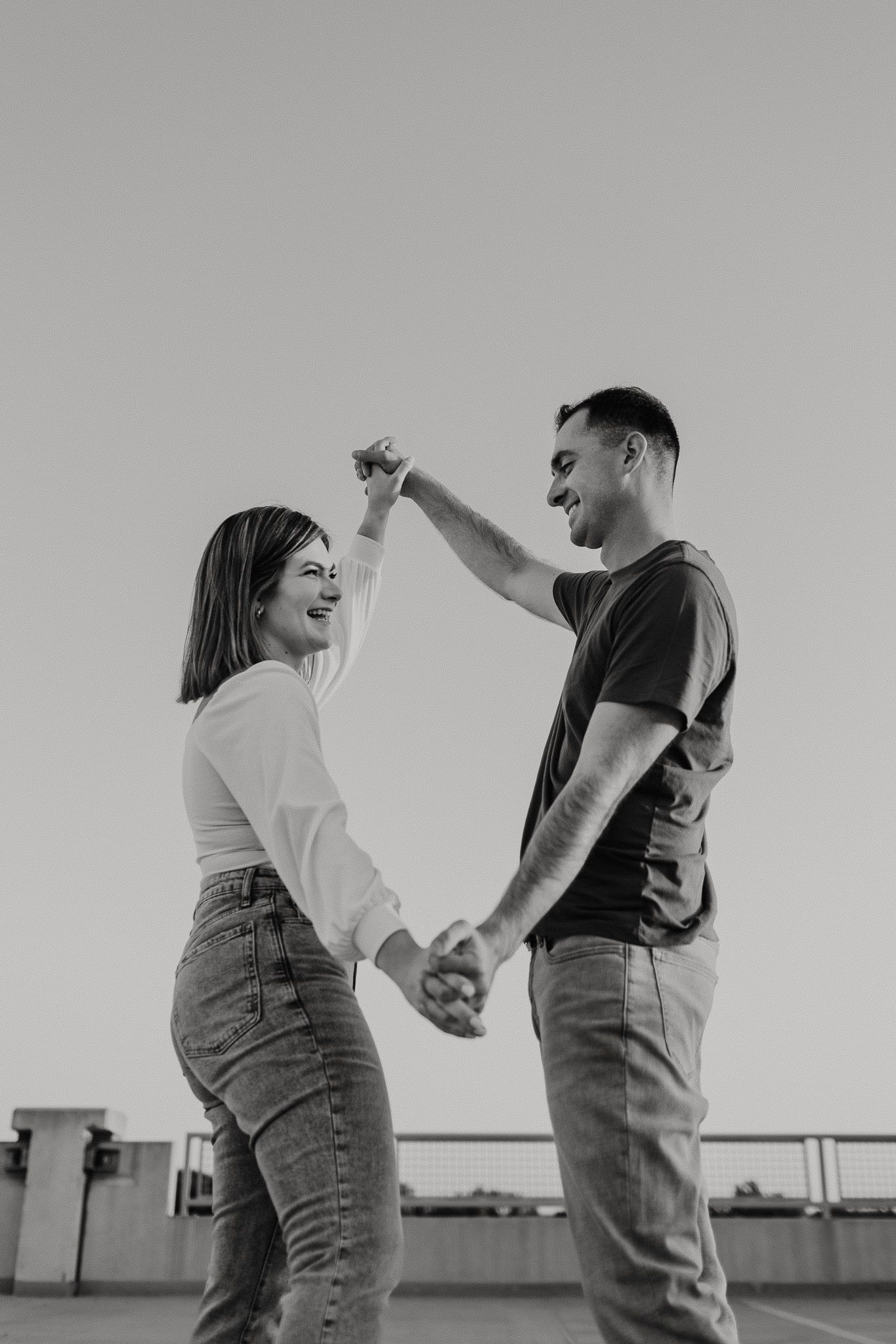 black and white of couple holding hands in diamond shape for artistic angle