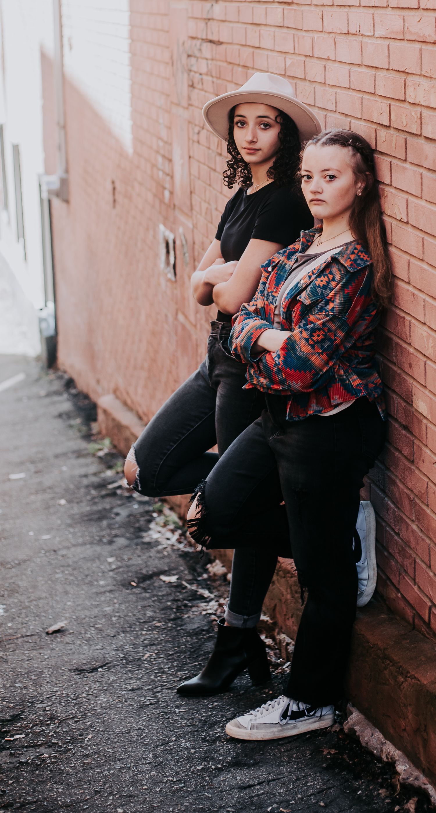 Urban photoshoot against brick wall featuring multiple poses in casual western attire.
