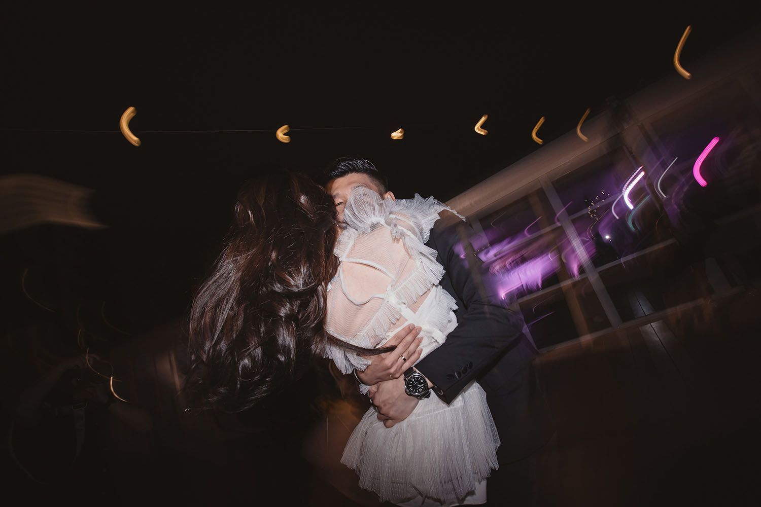 husband and wife hugging each other dancing in wedding after party