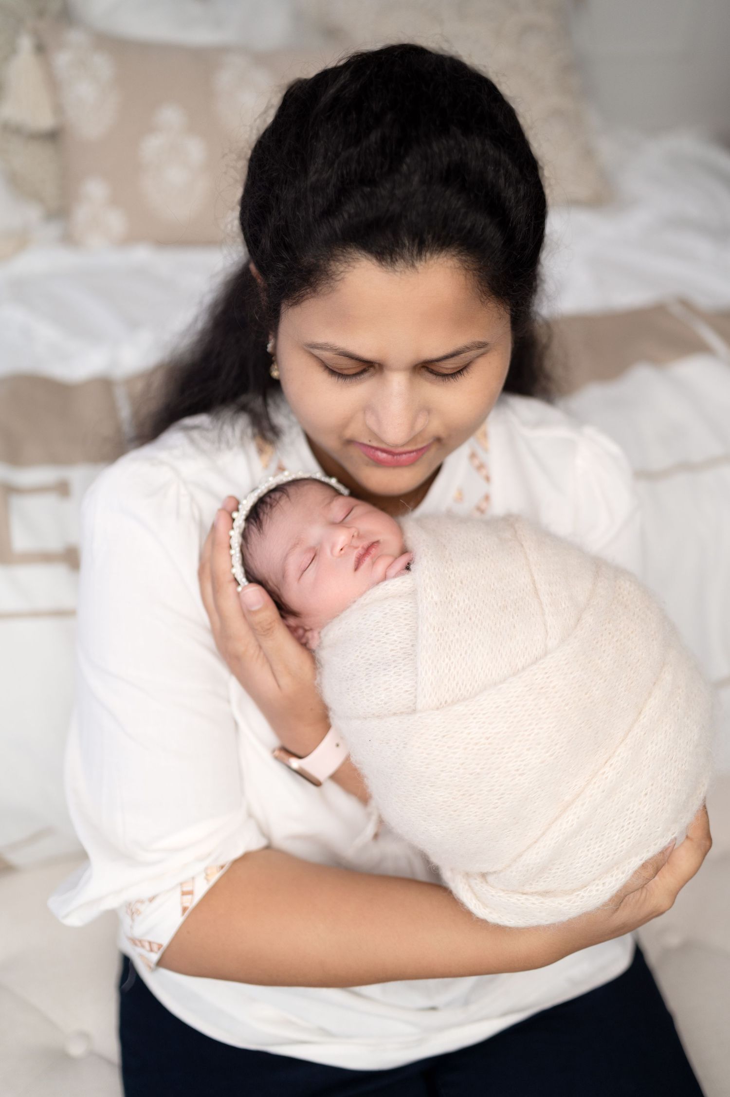Intimate newborn photography session showing gentle moments with family in soft lighting.
