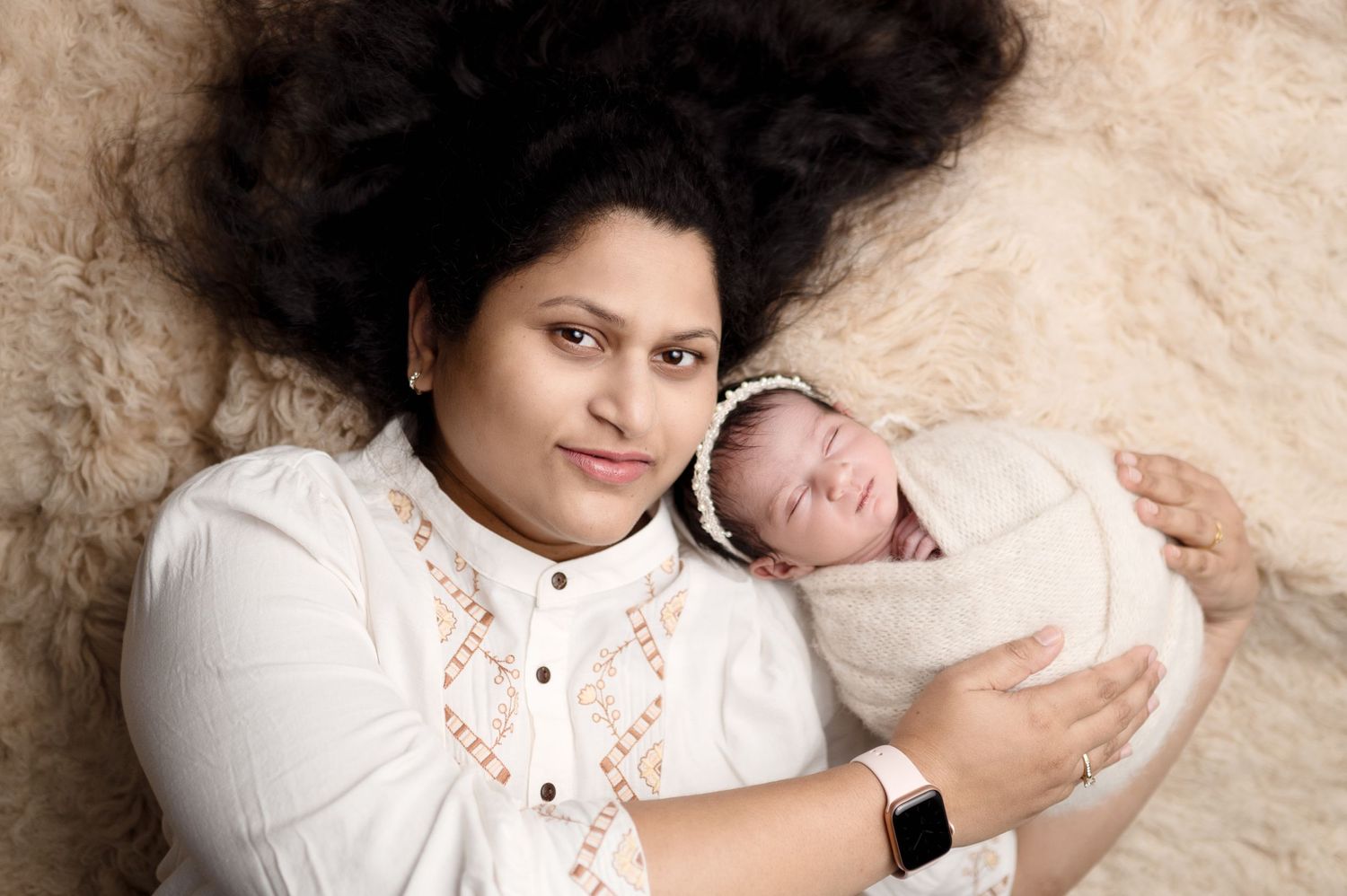 Intimate family moment captured in a series of soft, neutral-toned portraits on cream-colored bedding.
