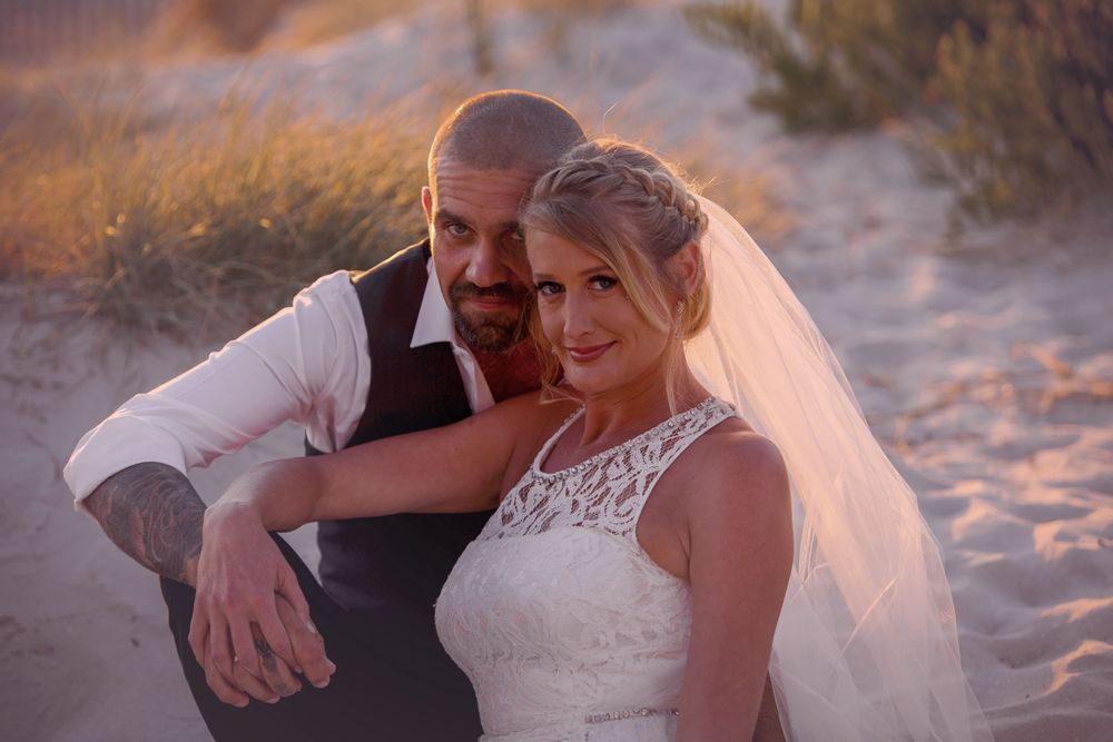 Romantic beach wedding photos show tender moments between newlyweds at sunset.