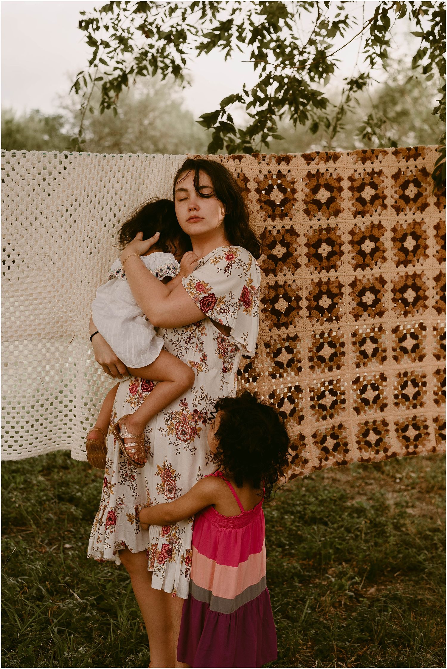 A heartwarming family moment captured against a vintage floral backdrop and tree branches.