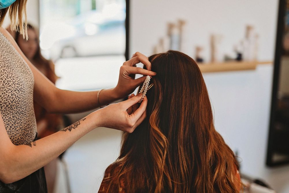 Hairstylist working on client's hair in modern salon setting.