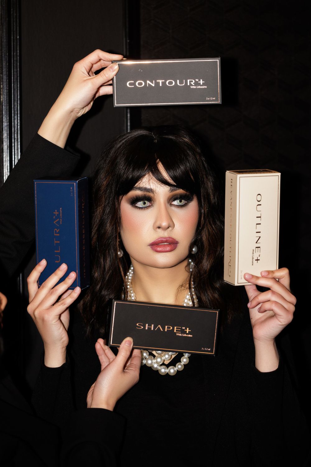 Beauty shot showcasing makeup brand product boxes against dark background.