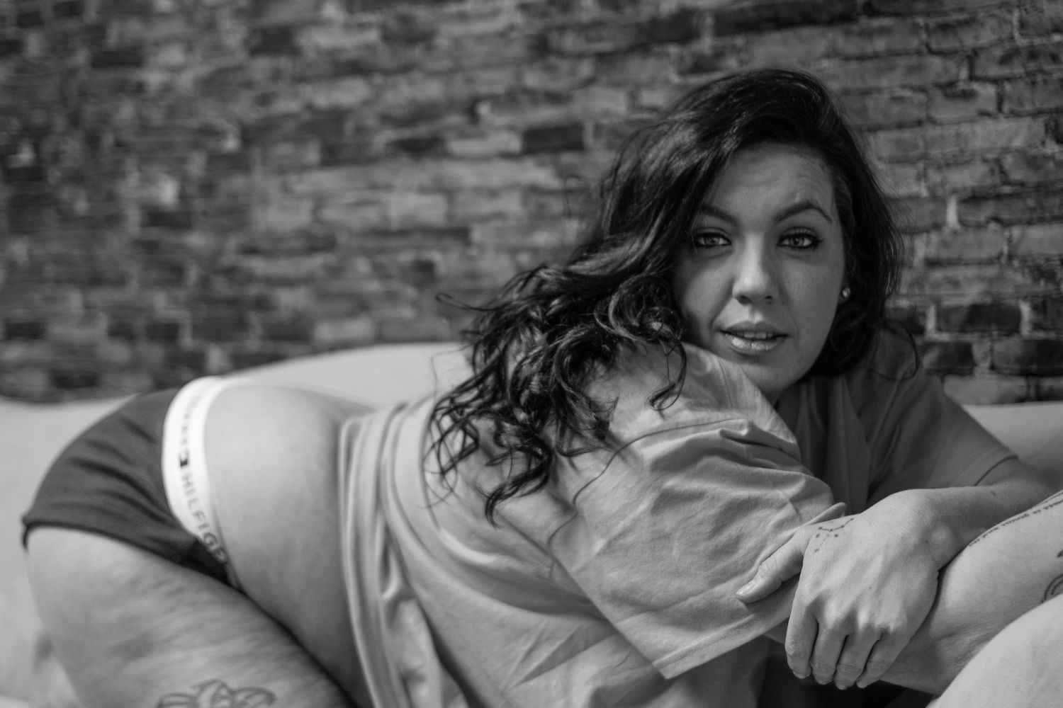 Person relaxing on couch in black and white portrait style.